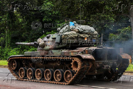 A tank drives on a road toward Thailand-Cambodia's border in Sisaket province, ahead of a ceasefire talks in Malaysia on the deadly border conflict between Thailand and Cambodia