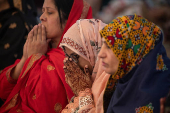 Woman raises henna adorned hands in devotion after Eid ul-Adha prayer in Lahore