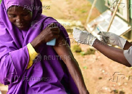 A Nigerian health official administer a mpox vaccination to a woman