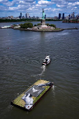 Drone view shows a grass covered barge with painting by Franco-Swiss artist Saype entitled ?Address Hate? towed past Statue of Liberty in New York Harbor