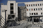 People gather near a damaged site, in Damascus