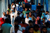 People board passenger ferries as they leave to celebrate Eid al-Adha with their families, in Dhaka