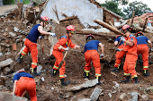 Firefighters during a search and rescue operation after flash floods brought by heavy rainfall at Shiwuzi village