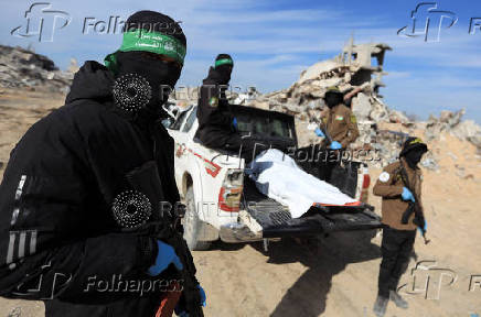 Palestinian Hamas and Islamic Jihad militants recover a body at a site as Hamas says it continues to search for the bodies of deceased hostages, in Beit Lahiya