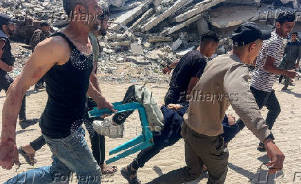Palestinians carry a victim after an Israeli airstrike, in Gaza City