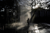 A child plays at a fountain in San Salvador