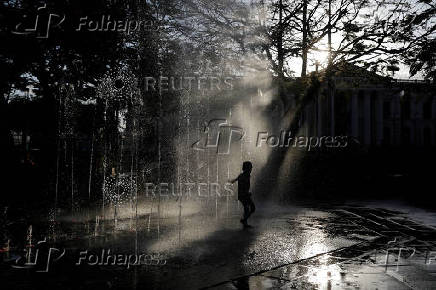 A child plays at a fountain in San Salvador