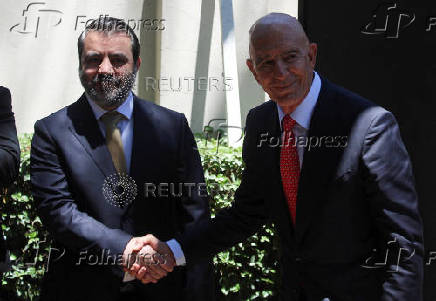 Syrian Foreign Minister Asaad Hassan al-Shibani shakes hands with U.S. envoy for Syria Thomas Barrack at U.S. ambassador's residency in Damascus