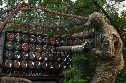 Ukrainian serviceman loads a rocket into a multiple launcher before firing towards Russian troops on a front line in Zaporizhzhia region