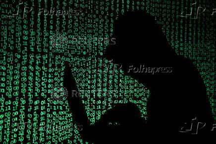 FILE PHOTO: Hooded man holds laptop computer as cyber code is projected on him in this illustration picture