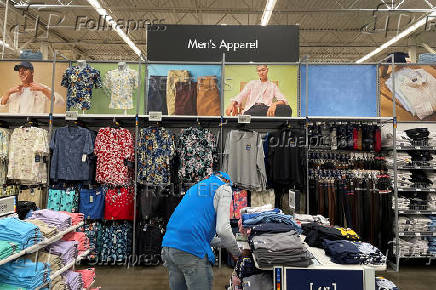 FILE PHOTO: A Walmart employee folds clothes in the men's apparel section at a Walmart Supercenter in North Bergen