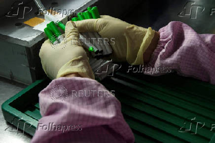 An employee tests electronic cigarettes at a production line in a factory in Shenzhen, southern Chinese province of Guangdong