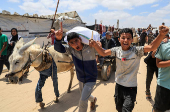 Palestinians carry aid supplies they received from the U.S.-backed Gaza Humanitarian Foundation, in Khan Younis