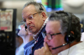 Traders work on the floor of the AMEX at the NYSE in New York