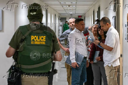 A migrant is detained by federal immigration officers at U.S. immigration court
