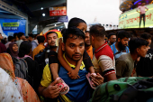 People board passenger ferries as they leave to celebrate Eid al-Adha with their families, in Dhaka