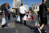 People shop in Jerusalem following an Israeli strike in Iran