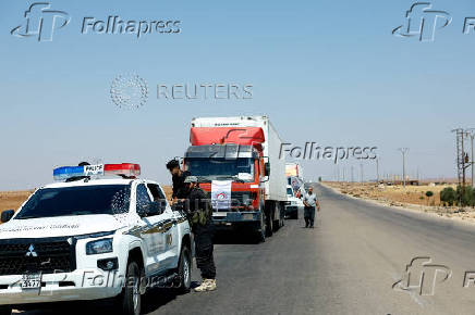 Vehicles carrying aid make their way to Sweida, at Bosra al-Sham, near Deraa