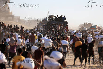 Palestinians carry aid supplies that entered Gaza through Israel, in Beit Lahia