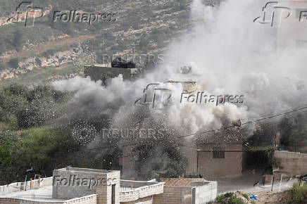 Smoke rises after the Israeli army blew up the house of a Palestinian assailant in Deir Ibzi town, near Ramallah