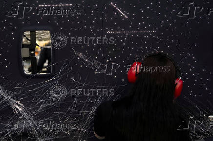 A technician works on a bespoke constellation design ceiling for a Rolls-Royce vehicle at Rolls-Royce Motor Cars' manufacturing plant in Goodwood