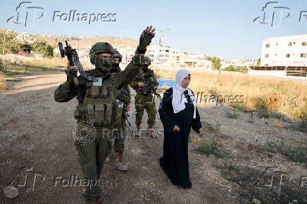 Israeli soldiers prevent Palestinians who came to visit the graves of their relatives from reaching the cemetery in Jenin camp
