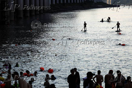 People ride paddle boards on Jialing River amid a red alert for heat in Chongqing