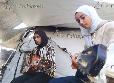 Crianças palestinas aprendem música para esquecer a guerra e a destruição.