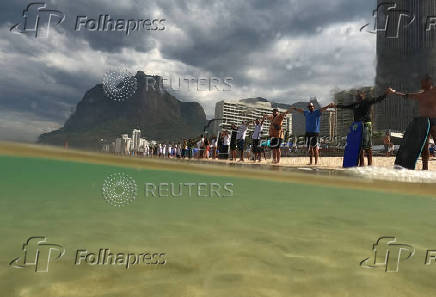 People attend a symbolic ritual named ?O Abraco' marking the World Oceans Day, at Sao Conrado beach in Rio de Janeiro