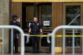 Police officers stand guard at the entrance of the Manhattan Criminal Court in New York