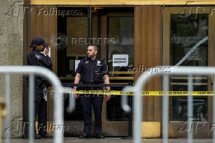 Police officers stand guard at the entrance of the Manhattan Criminal Court in New York