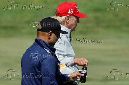 Walt Nauta, personal aide to former U.S. President Trump, walks with Trump at the Trump National Golf Club in Sterling, Virginia