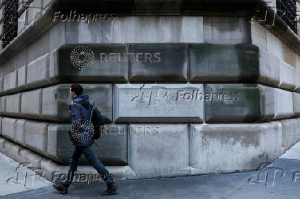 FILE PHOTO: A man passes by the corner stone on the Federal Reserve Bank of New York in the financial district in New York