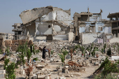 A person visits the graves of their relatives at a cemetery, on the first day of the Muslim holiday of Eid al-Adha, in Damascus