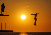 A man jumps into the Adriatic sea during warm weather in Zadar