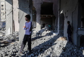 Palestinians inspect destroyed building after Israeli airstrike in Gaza City