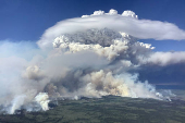 Smoke rises from wildfire G90216 north of Fort Nelson
