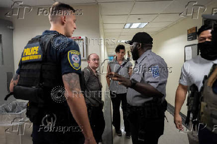 A migrant is detained by federal immigration officers at U.S. immigration court