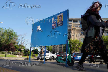 A woman passes near electoral posters in Bucharest