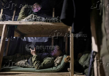 Servicemen of the Ukrainian Armed Forces rest in a dugout at a front line in Donetsk region