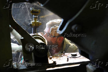Ukrainian servicemen fire a self-propelled howitzer towards Russian troops at a frontline near the town of Chasiv Yar