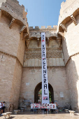 Protesters hang a giant banner that reads 
