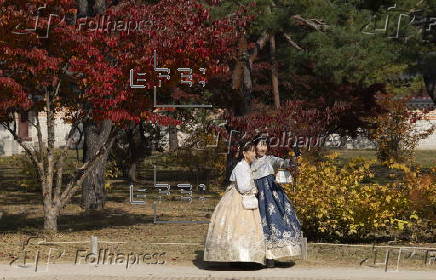 Tourists in Hanbok take selfies at Seoul’s Gyeongbokgung Palace
