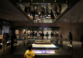 Tourists look at museum exhibits displayed at the Grand Egyptian Museum