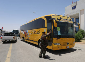 An Iraqi security officer gestures near buses carrying Iranian pilgrims at the Arar border crossing