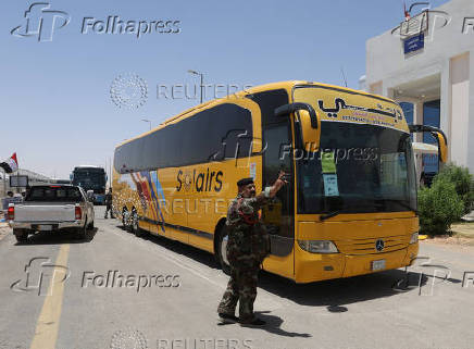 An Iraqi security officer gestures near buses carrying Iranian pilgrims at the Arar border crossing