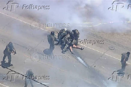 Tear gas billows from cannisters thrown by federal agents, during an immigration raid on an agricultural facility in Camarillo