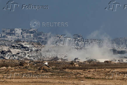 Israeli soldiers and military vehicles operate in Gaza, as seen from Israel
