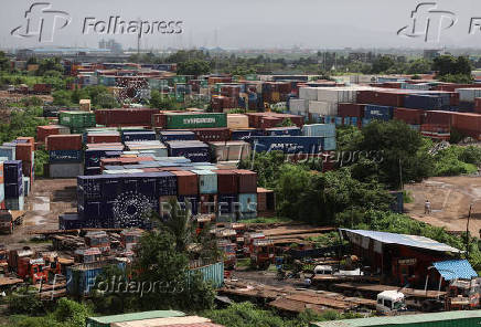 A man walks past shipping containers at a warehouse in Navi Mumbai