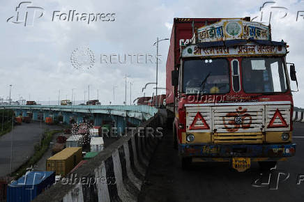 Trucks transporting shipping containers wait in line outside the Jawaharlal Nehru Port in Navi Mumbai